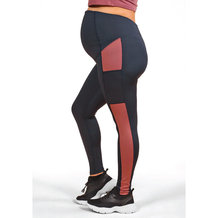 Athena Duo maternity leggings in black with red panels, shown on a pregnant person standing
