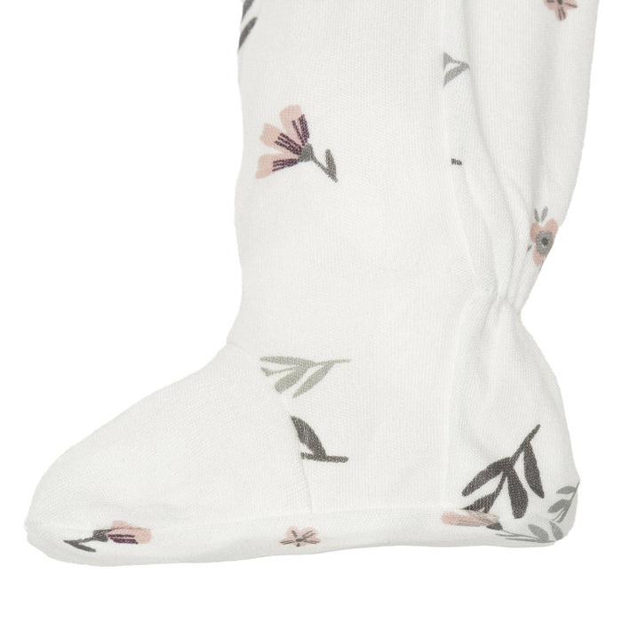 Close-up of white baby sleeper foot with soft pink and grey floral print