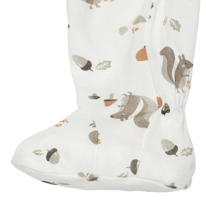 Close-up of white baby sleeper foot with squirrel and acorn print on bamboo fabric
