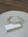 Pearl and silver decorative headband displayed on a textured light surface beside blank cards.