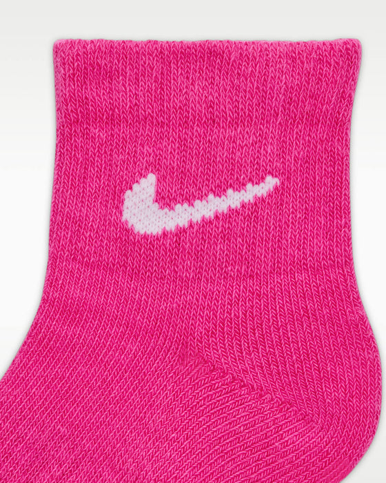 Pink quarter sock with white logo, close-up showing knit texture and ankle cuff.