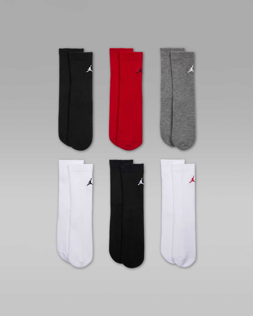 Jordan Essentials 6-pack crew socks in black, red, grey, and white, displayed on a flat surface.