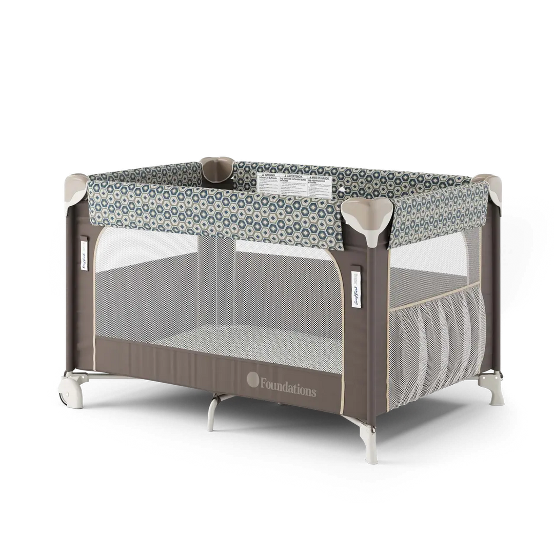 Foldable baby play yard with mesh sides, geometric patterned trim, and storage pocket.
