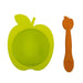 Green apple-shaped silicone baby bowl with matching orange spoon on white background