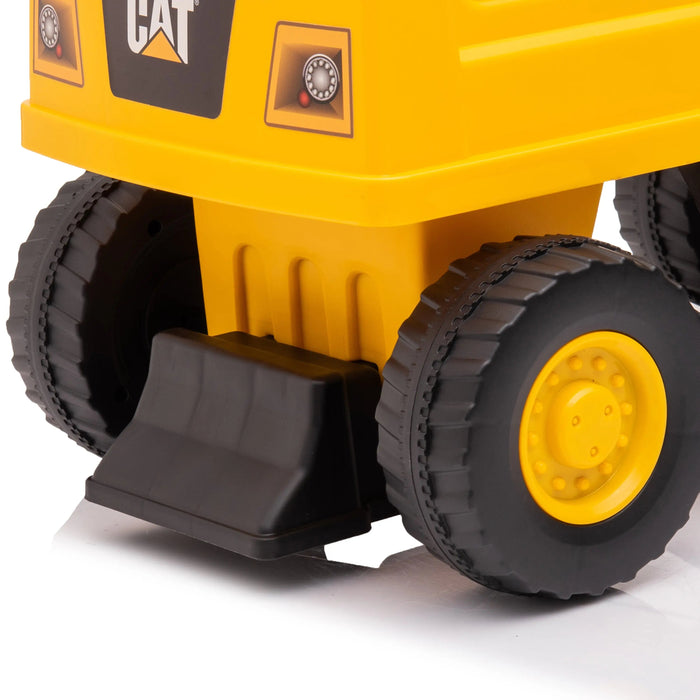 CAT toy dump truck closeup showing yellow plastic body and black wheels on a white background.