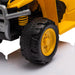 Kids ride-on toy car close-up showing yellow body and black plastic wheel on a white surface.