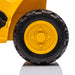 Toy dump truck close-up of large yellow and black wheel on a white background.