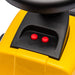 Close-up of a yellow ride-on toy steering wheel with two red buttons and black control panel.