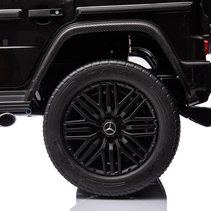 Black Mercedes-Benz toy SUV ride-on car rear wheel and door detail on white background.