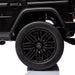 Black Mercedes-Benz toy SUV ride-on car rear wheel and door detail on white background.