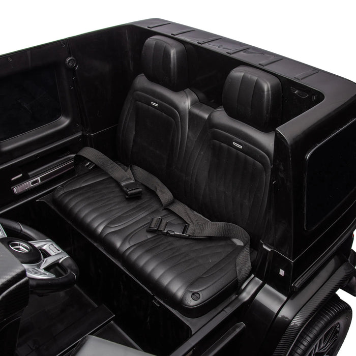 Black ride-on toy car interior with detailed seats and seat belts, viewed from above.