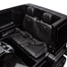 Black ride-on toy car interior with detailed seats and seat belts, viewed from above.