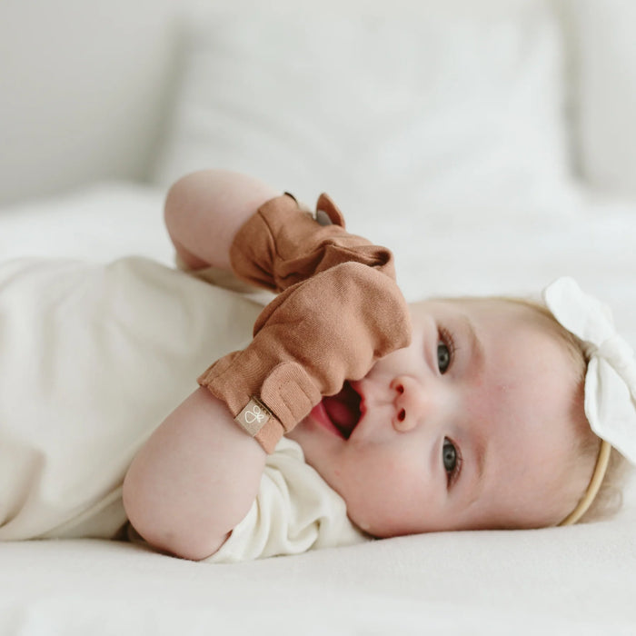 Cute baby with High Prairie anti-scratch Goumi mitts lying and smiling - Goldtex