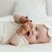 Cute baby with High Prairie anti-scratch Goumi mitts lying and smiling - Goldtex