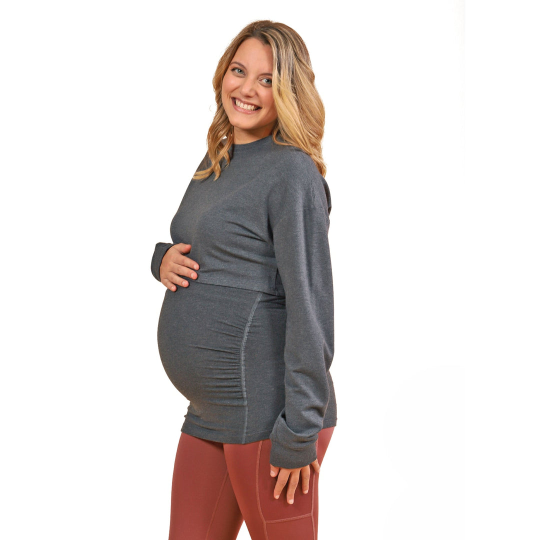 HERA-Grey maternity top shown on a smiling pregnant woman standing against a white background.