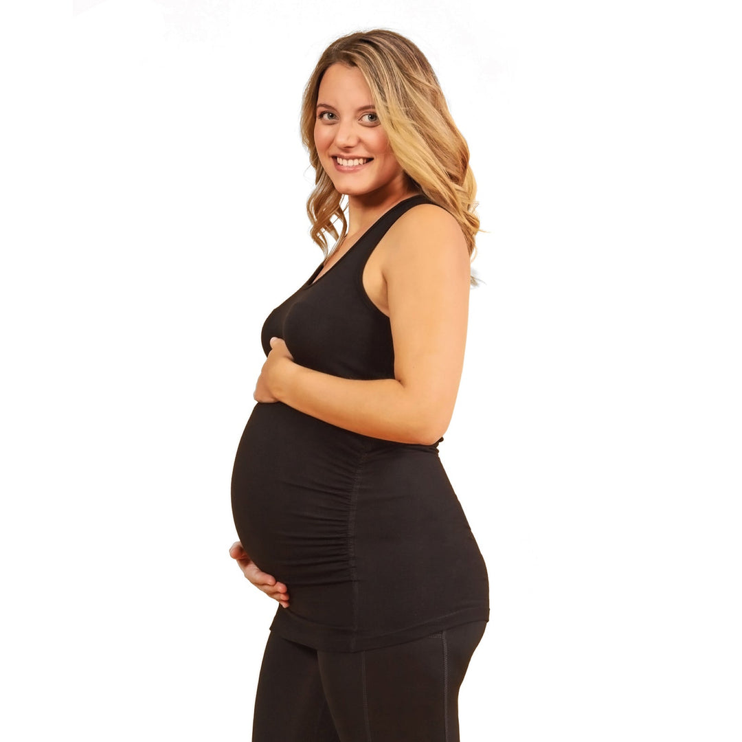 HESTIA maternity tank top in black worn by a pregnant woman smiling against a white background.