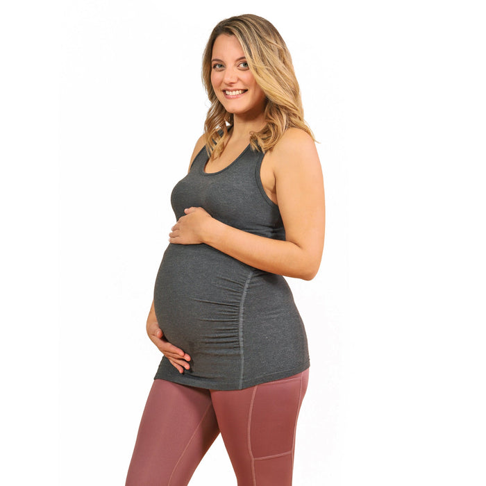 HESTIA grey maternity tank top worn by a smiling pregnant woman standing against a white background.