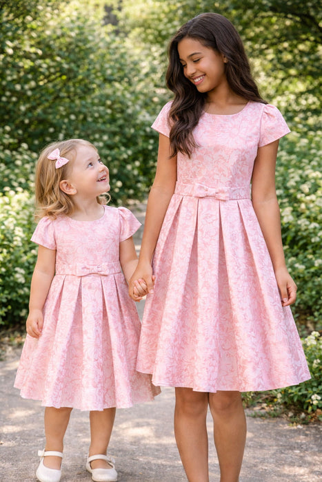 JKS81 rose gold party dress shown on two girls holding hands outdoors, featuring short sleeves and floral pattern.