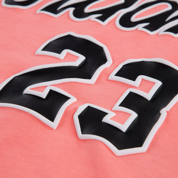 Kids pink sweatshirt with raised black and white number 23 detail on the front, close-up view.