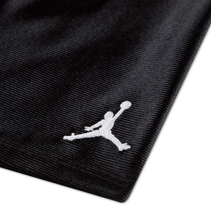 Jordan kids' black fabric with white Jumpman logo embroidered in the corner, close-up view.