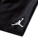 Jordan kids' black fabric with white Jumpman logo embroidered in the corner, close-up view.