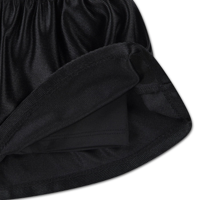 Girls’ black pleated skirt close-up showing inner shorts and elastic waistband detail.