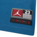 Jordan blue fabric close-up featuring Jumpman patch and number 23 on stitched label.