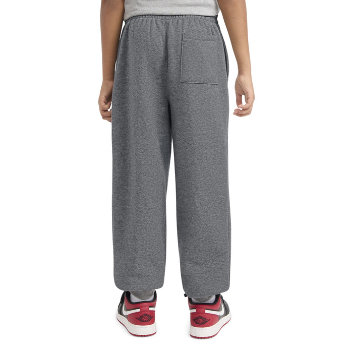 JOR-95F113-GEH grey kids sweatpants shown from the back, worn by a child standing.