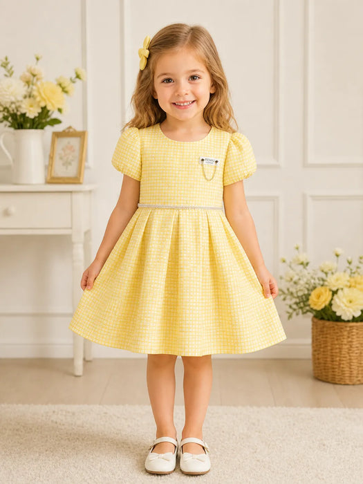 KIDS ENERGY Yellow Dress shown on smiling girl standing in a bright, floral-decorated room.