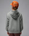 Boy in a grey hooded fleece zip sweater and orange cap shown from the back against a plain background.