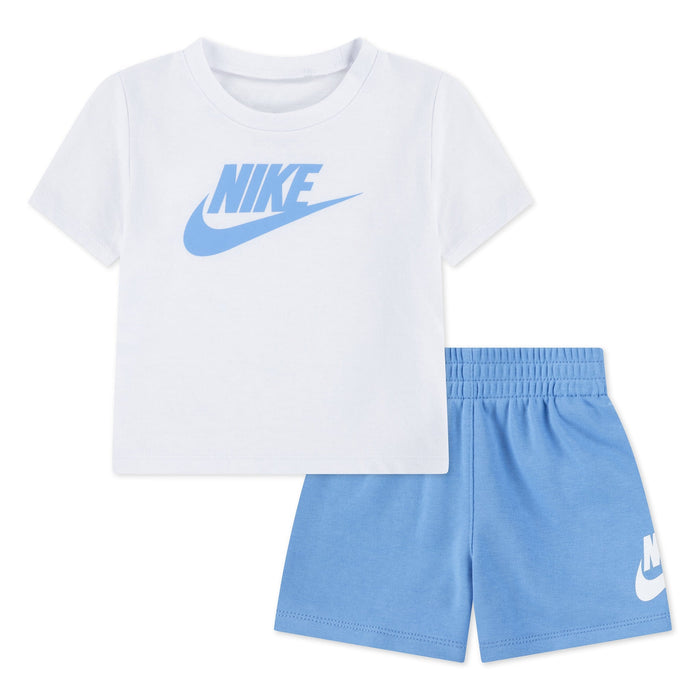Nike baby set with white logo t-shirt and light blue shorts displayed on a white background.