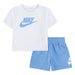 Nike baby set with white logo t-shirt and light blue shorts displayed on a white background.