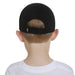 Nike kids’ black cap shown on a child, rear view highlighting adjustable strap and logo detail.