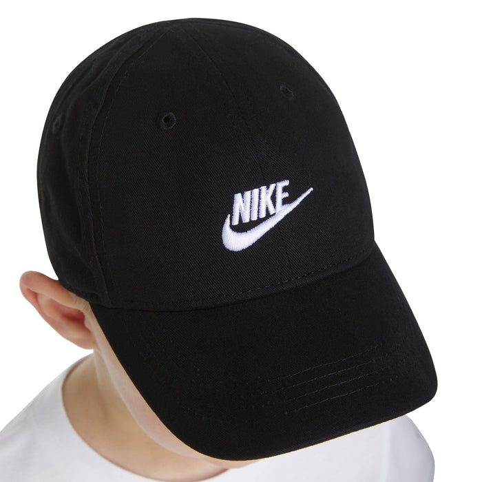 Nike black baseball cap with white logo worn by a child, viewed from above.
