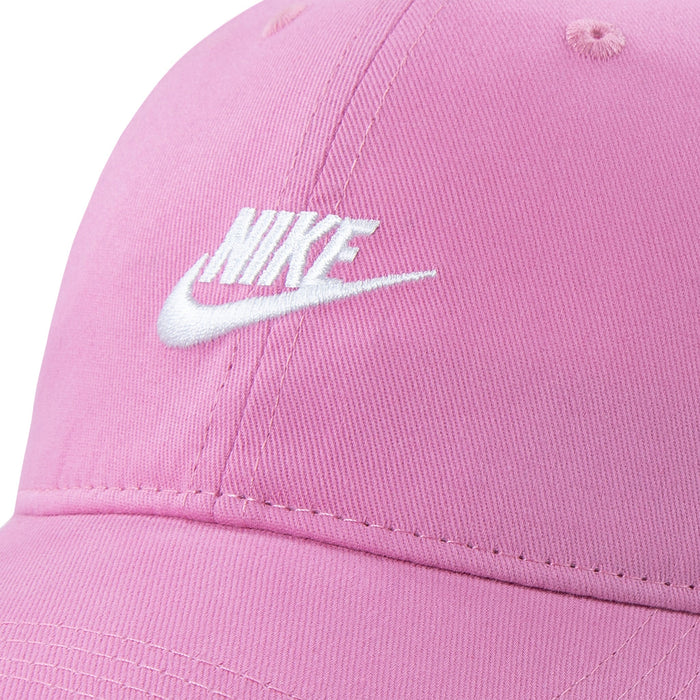 Nike pink baseball cap with white embroidered logo, shown in close-up detail.