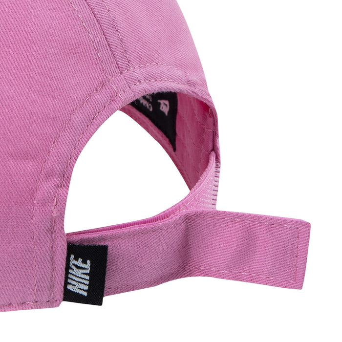 Nike pink adjustable cap close-up showing back strap and logo tag.