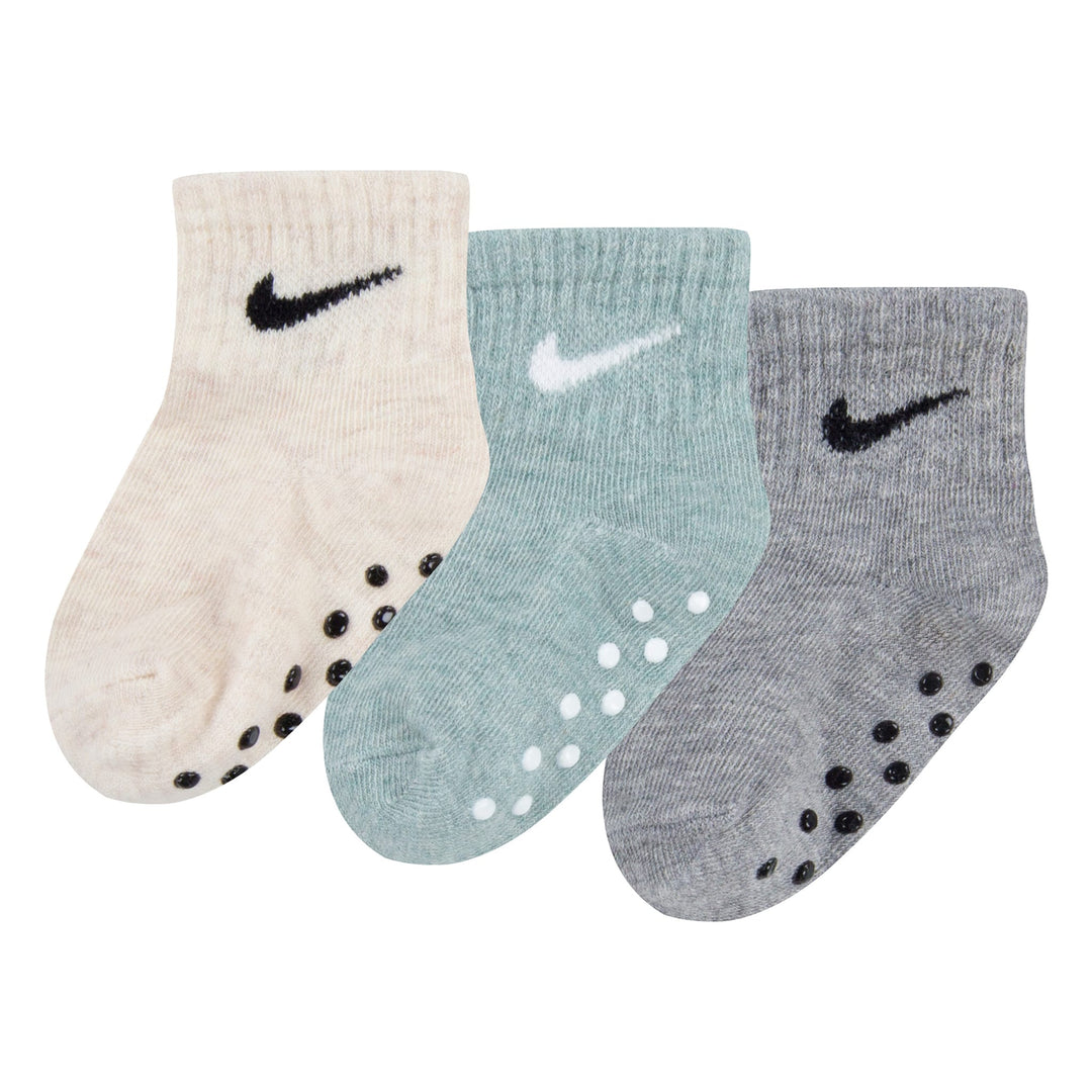 Nike baby non-slip socks in beige, light blue, and grey, displayed side by side on white background.