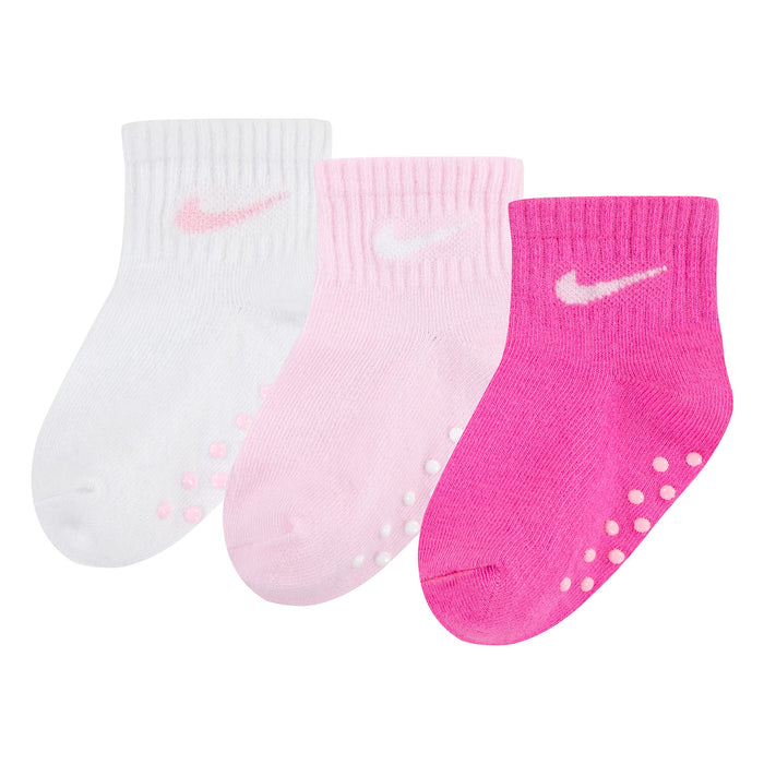 Nike baby girls' non-slip socks in white, light pink, and dark pink shown side by side on white background.
