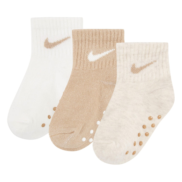 Nike baby crew socks in cream, beige, and white, shown in a set of three with anti-slip soles.