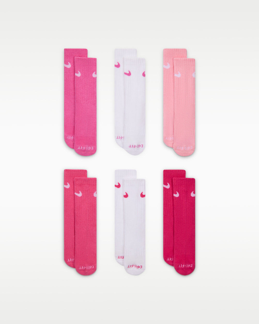 Nike kids' crew socks in assorted shades of pink and white, displayed flat in pairs.