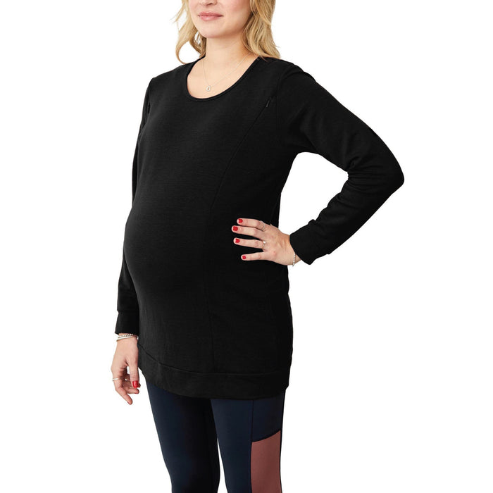 NIXI black maternity top shown on a pregnant woman standing with hand on her hip against white background.