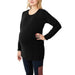 NIXI black maternity top shown on a pregnant woman standing with hand on her hip against white background.