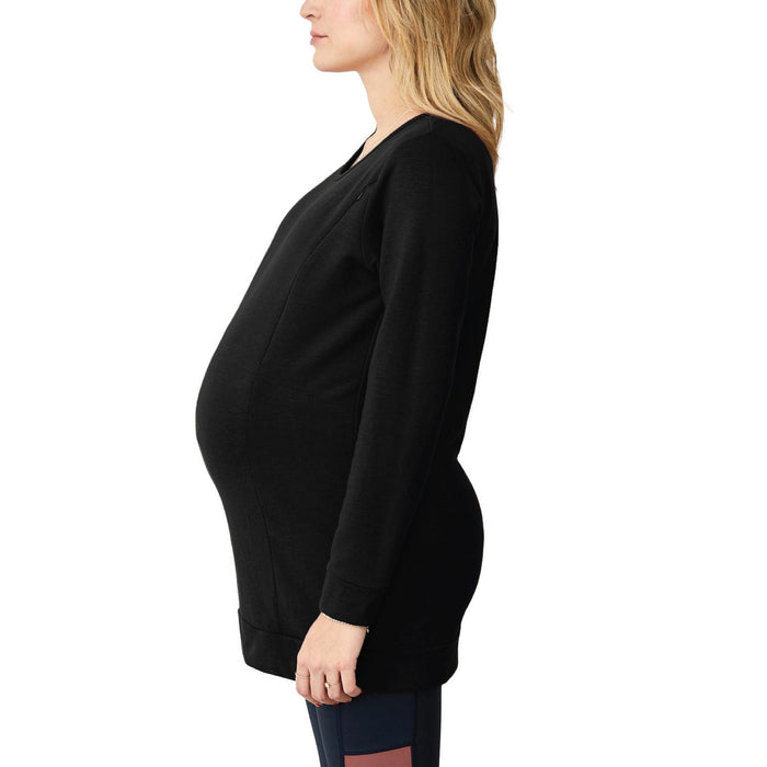 NIXI maternity tunic in black shown on a pregnant woman in side profile against a white background.