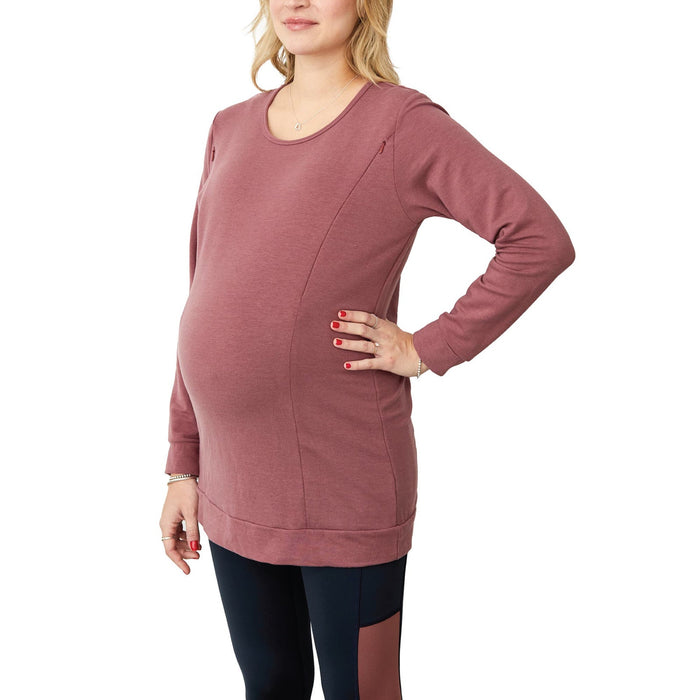 NIXI-F maternity top in mauve worn by a pregnant woman standing against a white background.