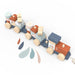 Wooden stacking train toy in pastel colors displayed on a white background.