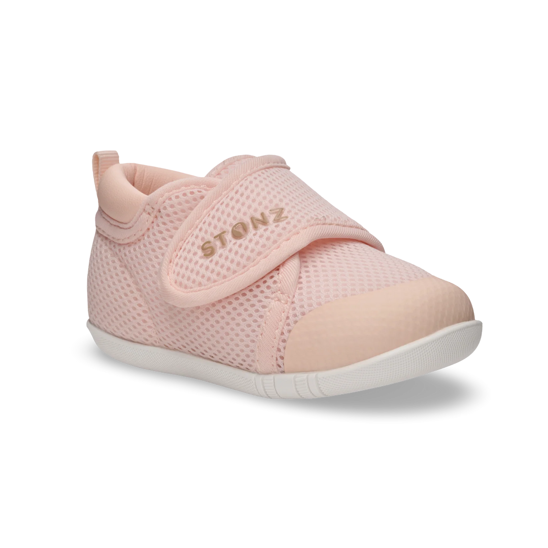 Light pink breathable mesh baby sneaker with velcro strap and white sole, side view