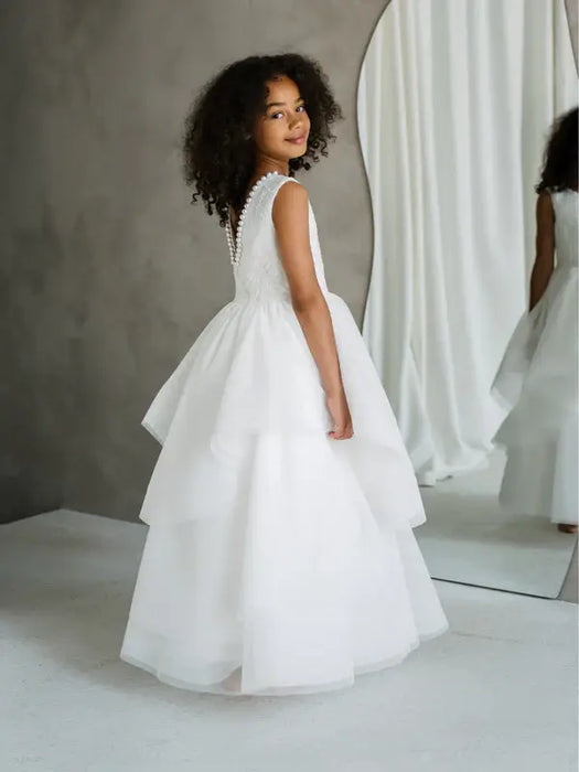 JK07 Pearl Back Horsehair Communion Dress shown on a girl standing in front of a mirror.