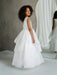 JK07 Pearl Back Horsehair Communion Dress shown on a girl standing in front of a mirror.