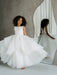 Sunny JK07 Pearl Back Horsehair Communion Dress shown on a young girl twirling beside a mirror.