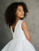 Sunny JK07 Pearl Back Horsehair Communion Dress shown on a smiling girl facing away, highlighting pearl details.